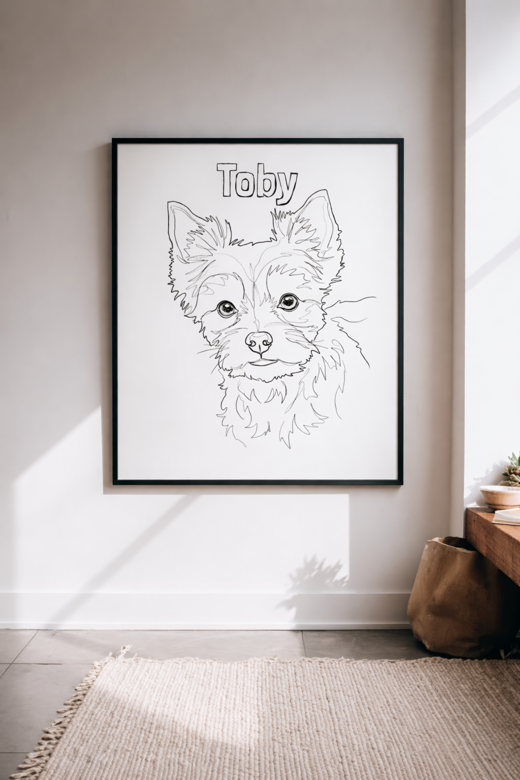 Line art pet portrait of a Yorkshire Terrier named Toby in a black frame on a wall